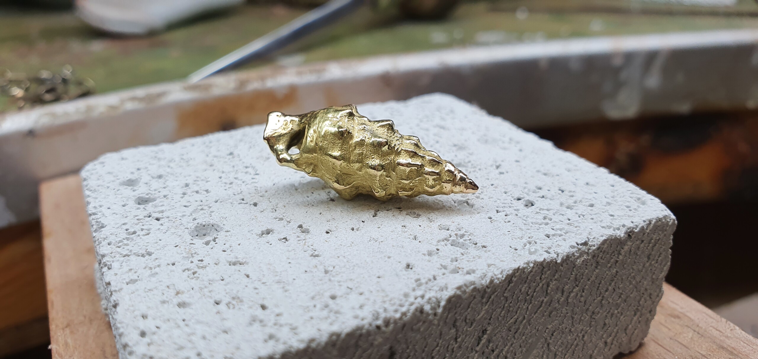Ciondolo conchiglia Orme – Oro 18kt fuso in sabbia Ciondolo artigianale a forma di conchiglia in oro giallo 18kt, realizzato con l'antica tecnica della fusione in sabbia.