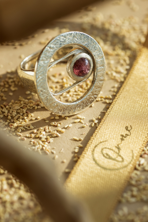 Dettaglio macro dell'incastonatura a mano su anello materico Seventy, gioiello artigianale in argento e pietra naturale.