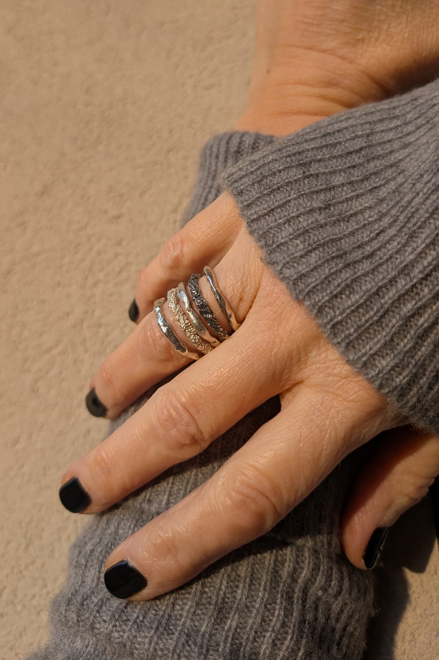 Mano con set di anelli Caleidos: il Frammento di Roccia abbinato ad argento naturale.