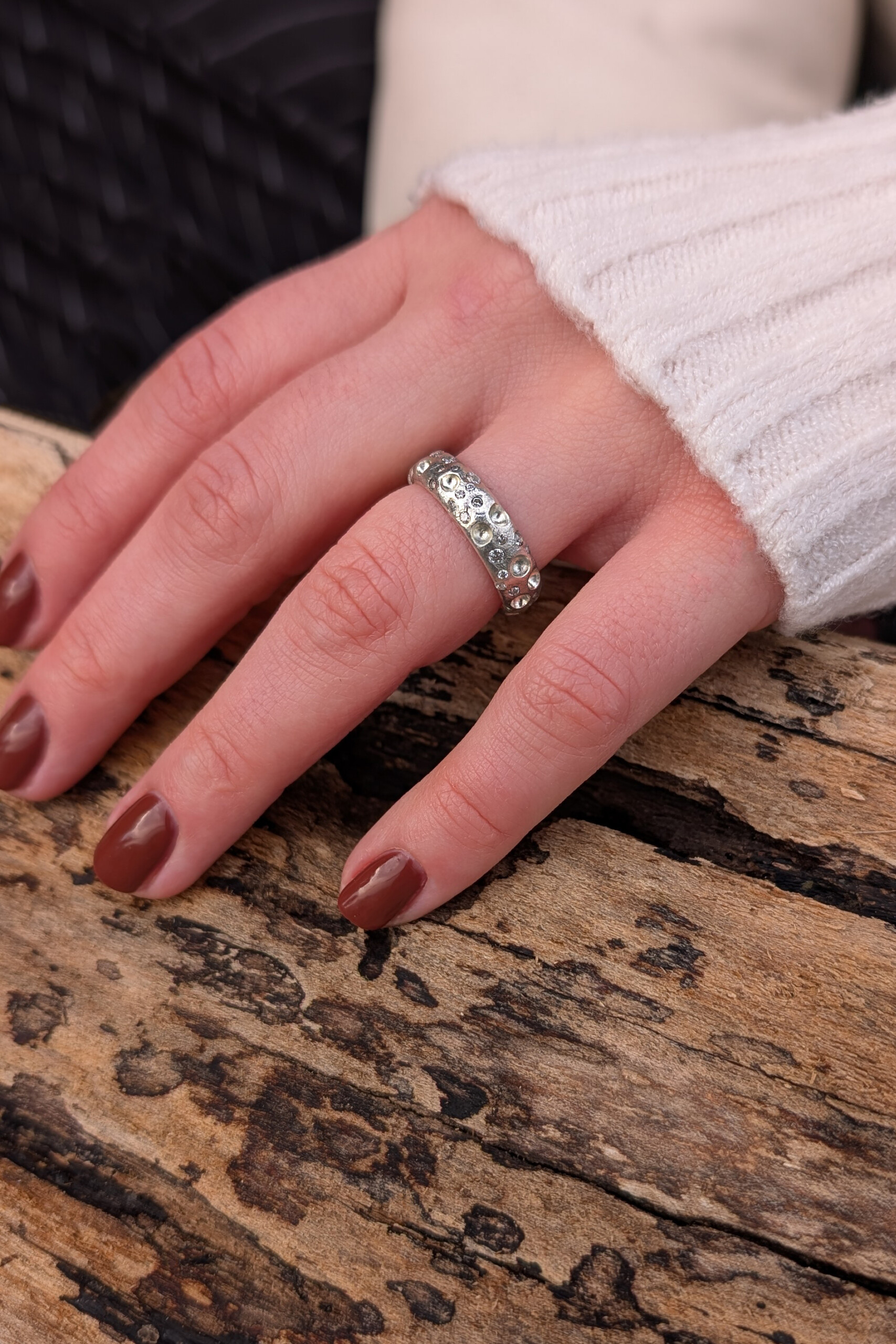 Mano di donna che indossa l'anello Cratere con zirconi, disponibile nel nostro laboratorio ecommerce di gioielli artigianali.