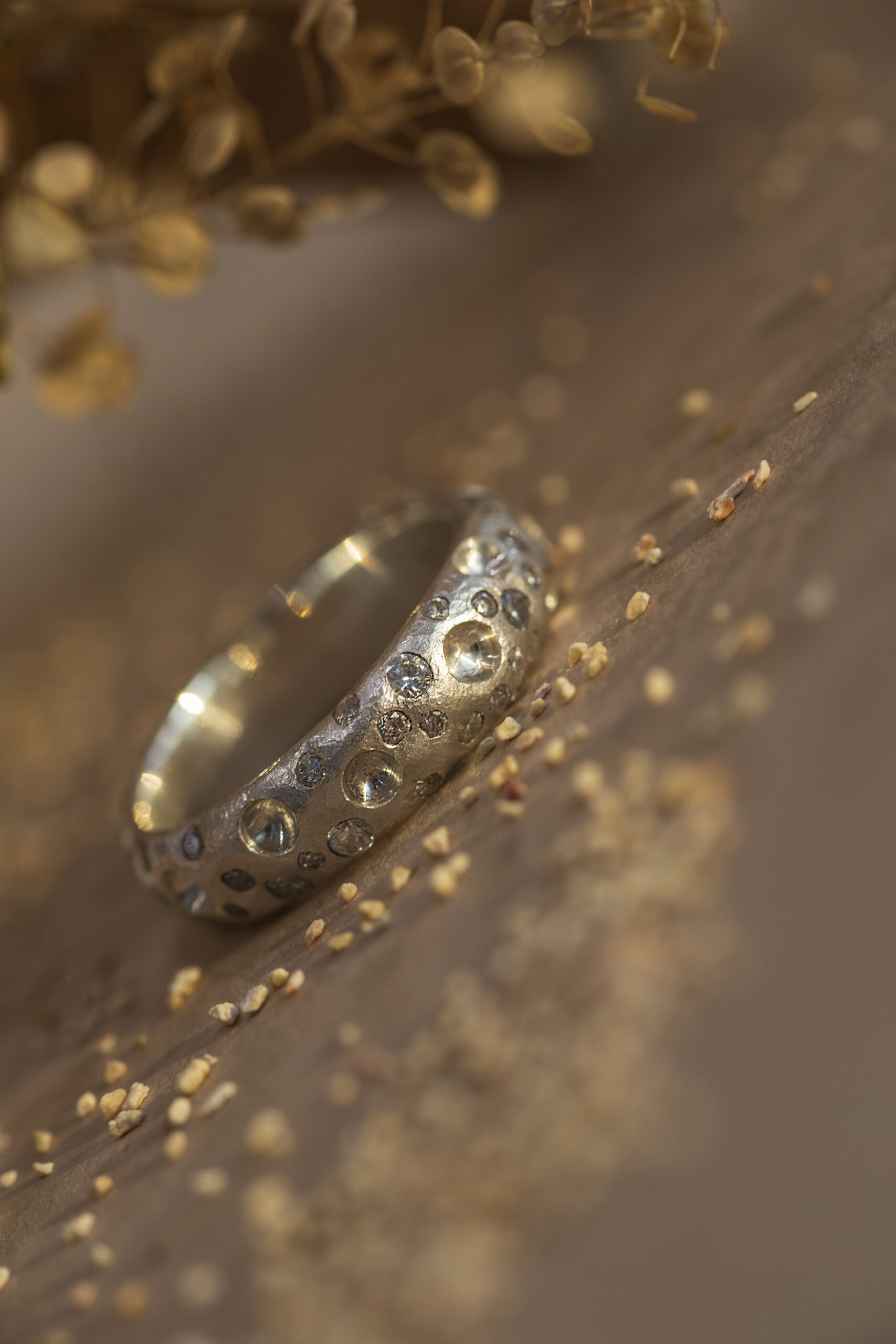 Dettaglio macro dell'anello Cratere in argento 925 con piccoli zirconi luminosi incastonati nella texture materica.