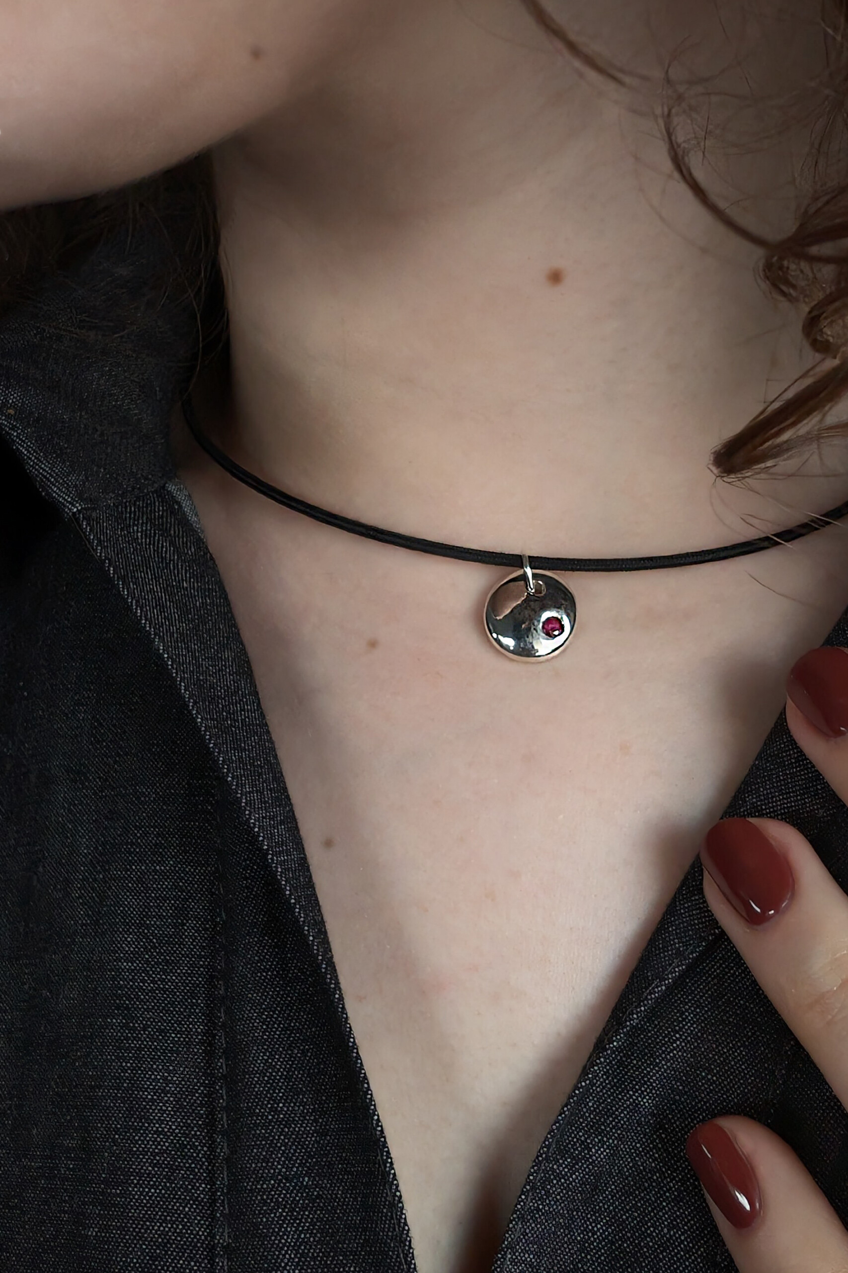 Foto lifestyle di una collana girocollo con pendente Pepita e rubino, perfetta per uno stile minimalista, acquistabile nel nostro laboratorio ecommerce.