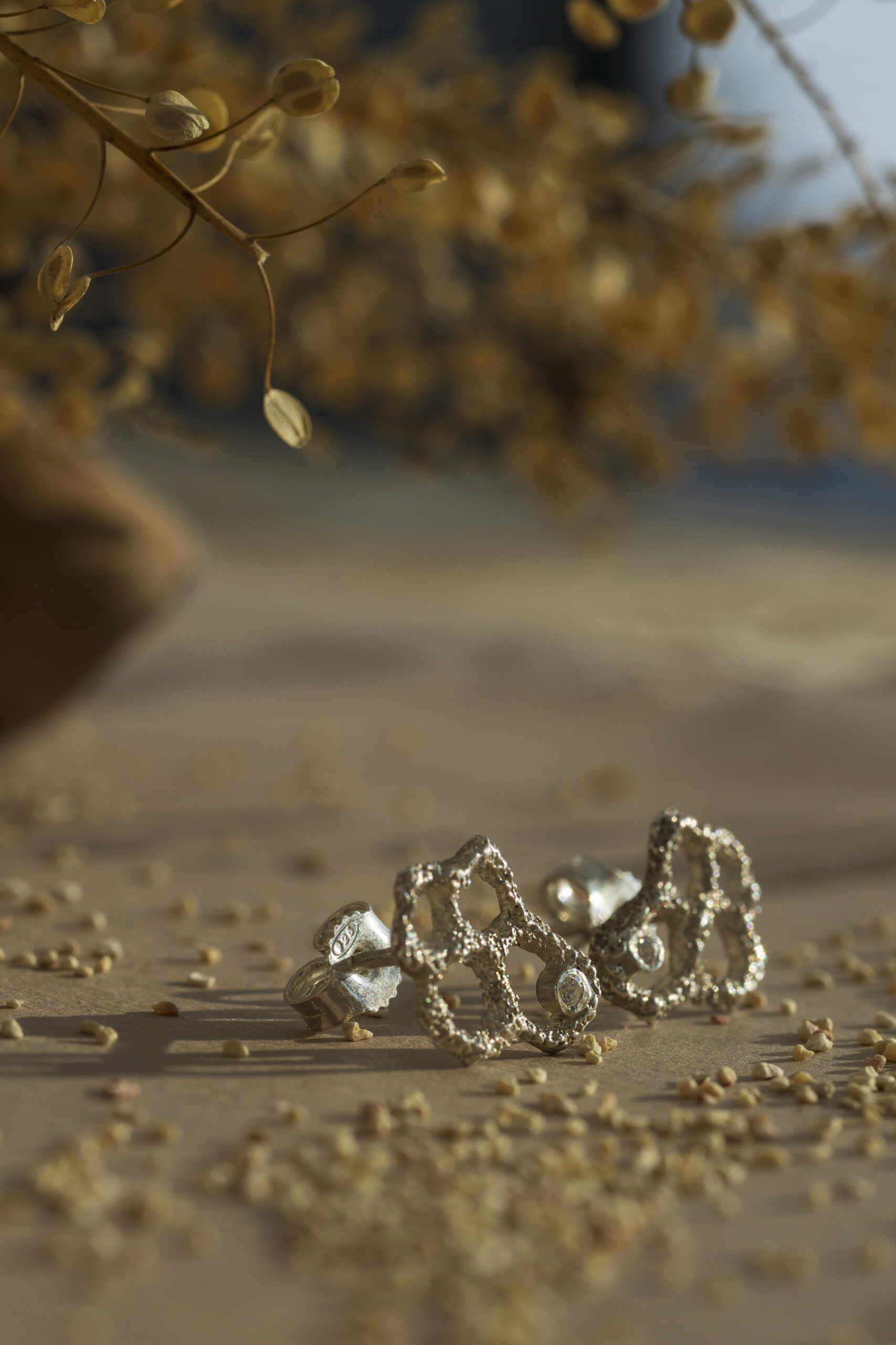 Vista prospettica laterale degli orecchini piccoli Nebula che mostra la chiusura a farfallina e la finitura irregolare dell'argento 925 fatto a mano.