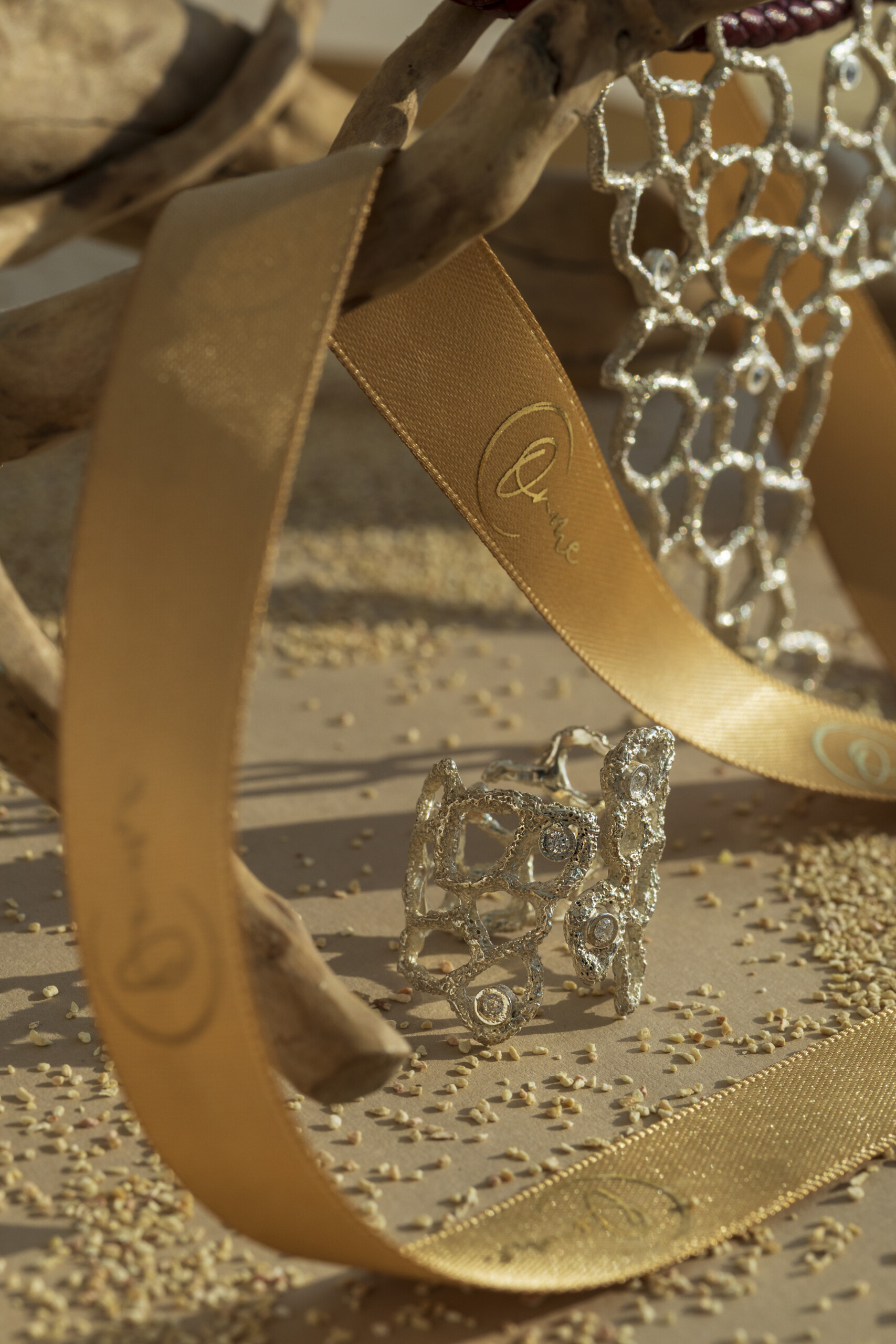 Composizione dell'anello Nebula con nastro logato; un gioiello materico ottenuto tramite fusione a cera persa per creare un intreccio organico unico.