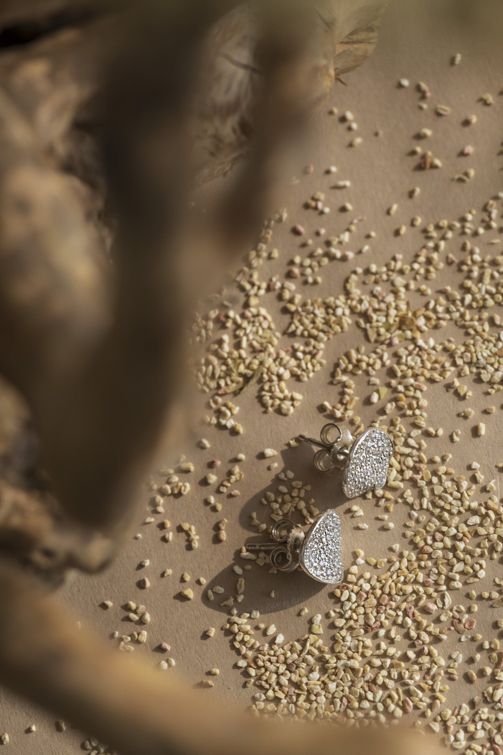 Vista dall'alto degli orecchini a lobo Moon con pavé di zirconi; la forma irregolare richiama la superficie lunare ed è ideale per uno stile minimalista.